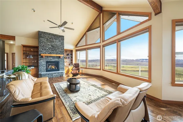 a living room with fireplace furniture and a large window