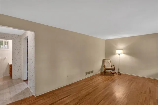 a view of a room with wooden floor a table and a chair