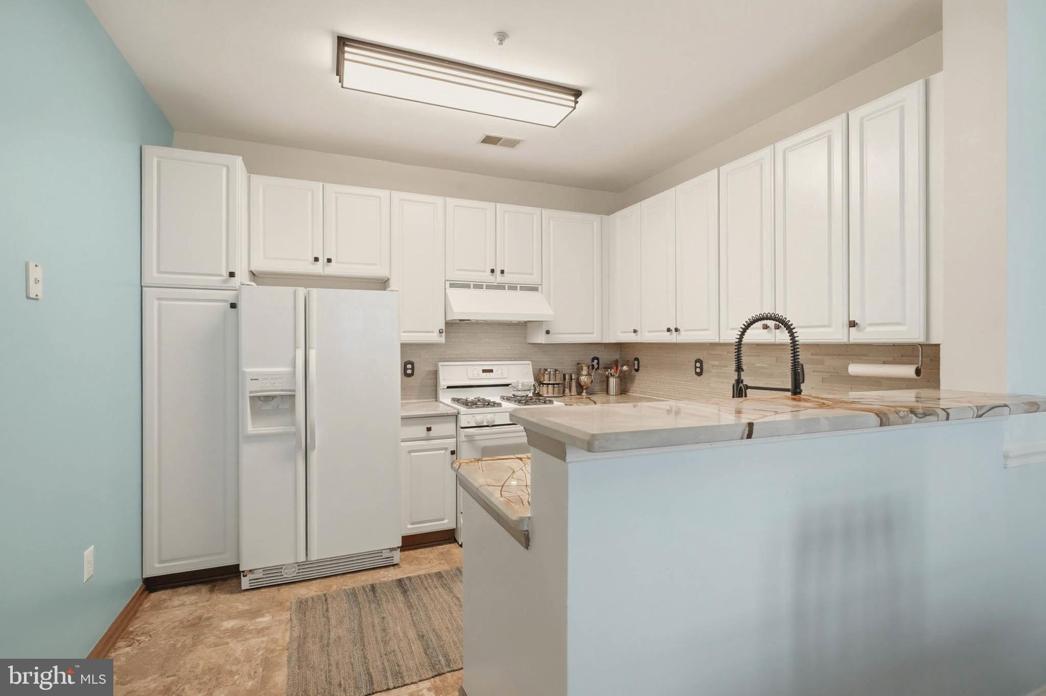 8721 Spring Brook Way Odenton, MD 21113 - Photo 7 of 40 a kitchen with stainless steel appliances granite countertop a refrigerator sink and white cabinets