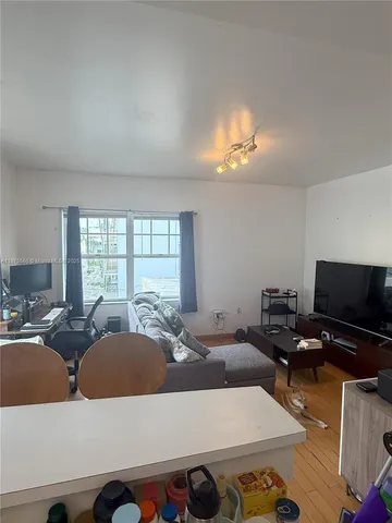 a living room with furniture a chandelier and a flat screen tv