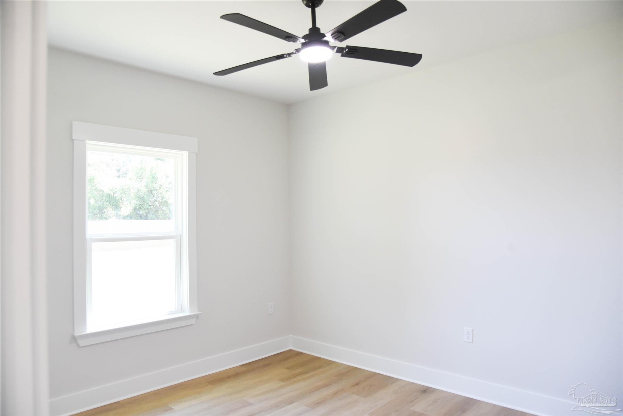 8080 Pinus Lane Pensacola, FL 32534 - Photo 12 of 25 an empty room with a window and wooden floor