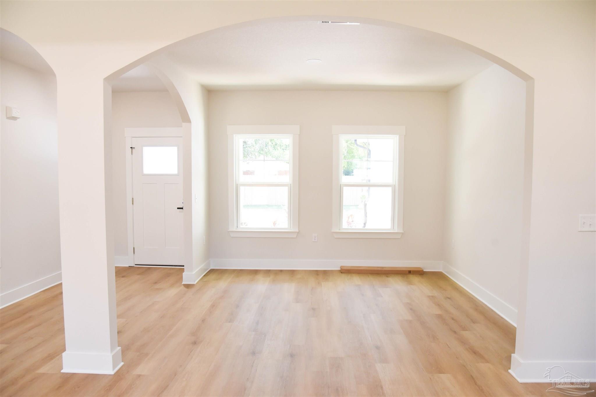 8080 Pinus Lane Pensacola, FL 32534 - Photo 5 of 25 an empty room with wooden floor and windows