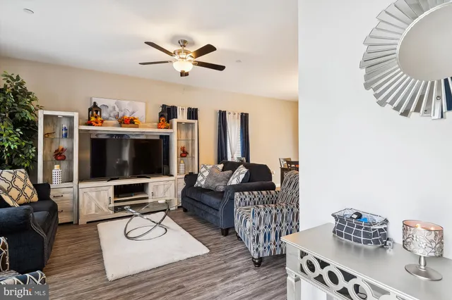 a living room with furniture a flat screen tv and a window