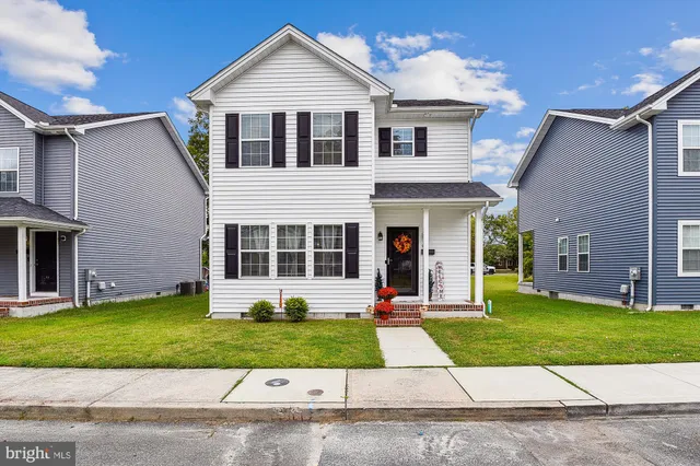 a front view of a house with a yard and potted plants