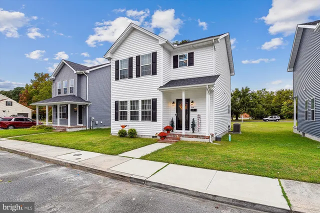 a front view of a house with a yard and trees