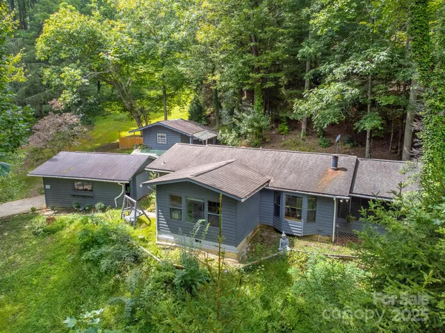 a aerial view of a house with swimming pool and large trees