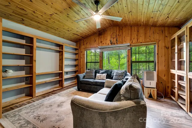 a living room with furniture large window and a chandelier