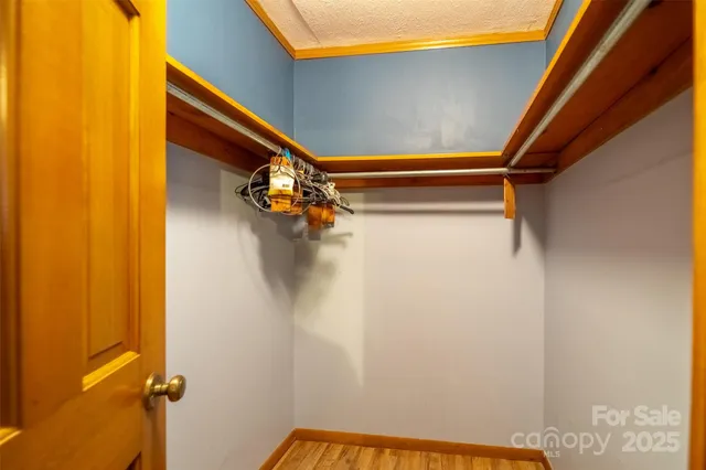 a view of a big room with wooden floor and windows