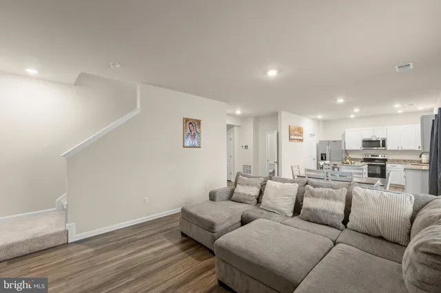 a living room with furniture and a view of kitchen