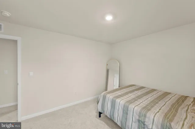 a bedroom with a bed and a white wall