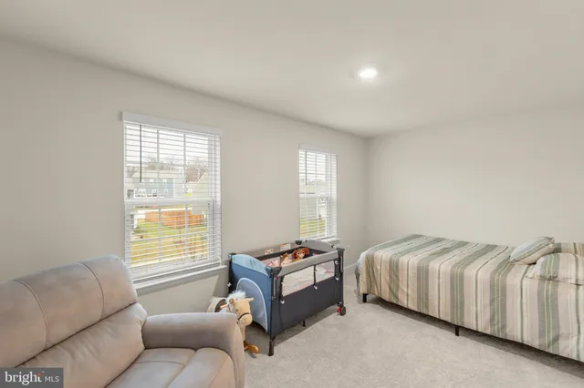 a bedroom with a bed and a couch with exposed radiator
