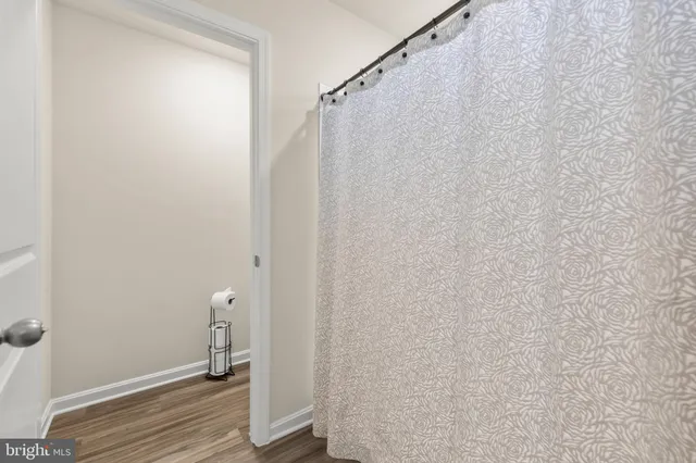 a view of a room with wooden floor and white walls