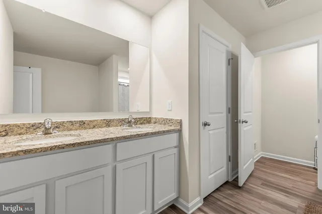 a bathroom with a granite countertop sink and a mirror