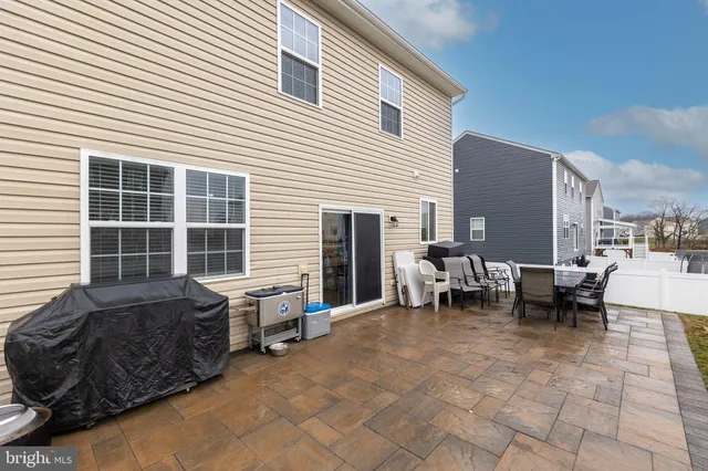 a view of a patio with a table and chairs and a barbeque