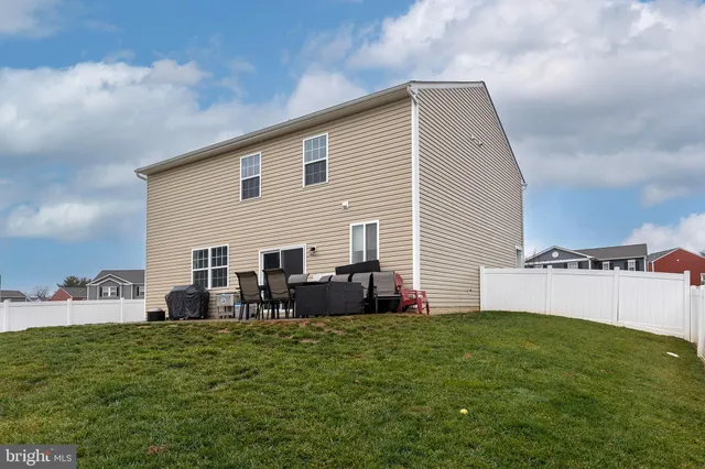 a view of a house with backyard and sitting area