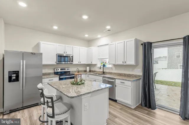 a kitchen with a sink a counter top stainless steel appliances and cabinets