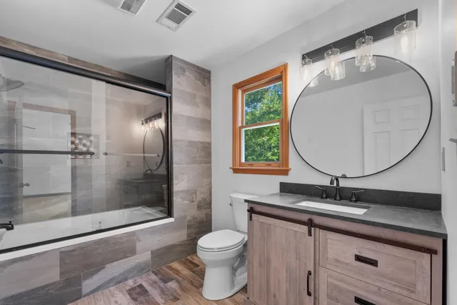 a bathroom with a granite countertop sink toilet and shower