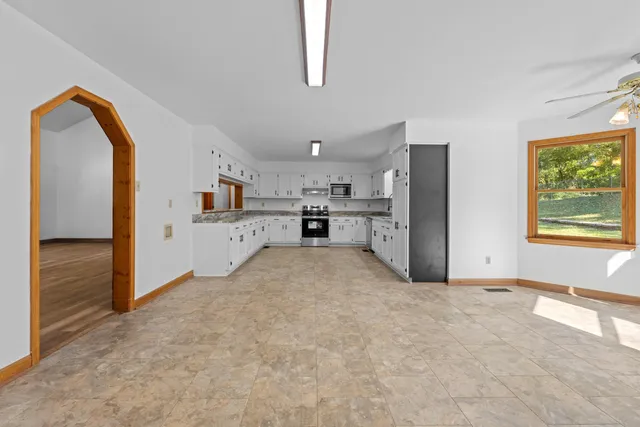 a kitchen with granite countertop white cabinets and stainless steel appliances