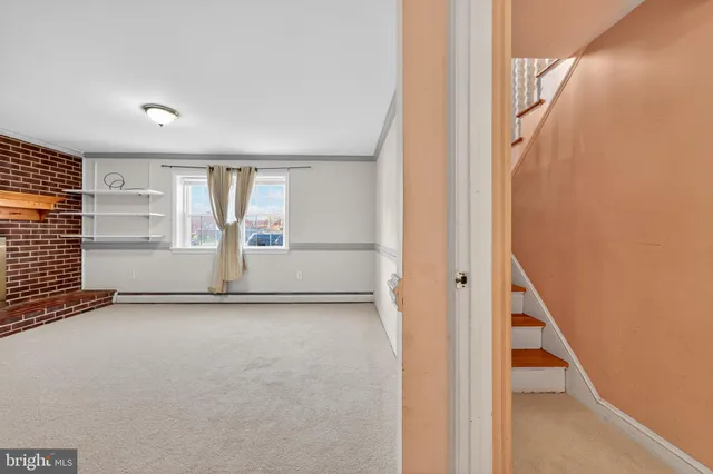 a view of empty room with fireplace and windows