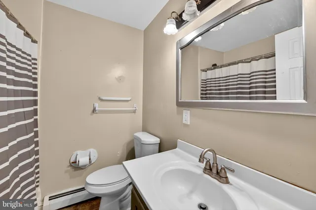 a bathroom with a sink a toilet and a mirror