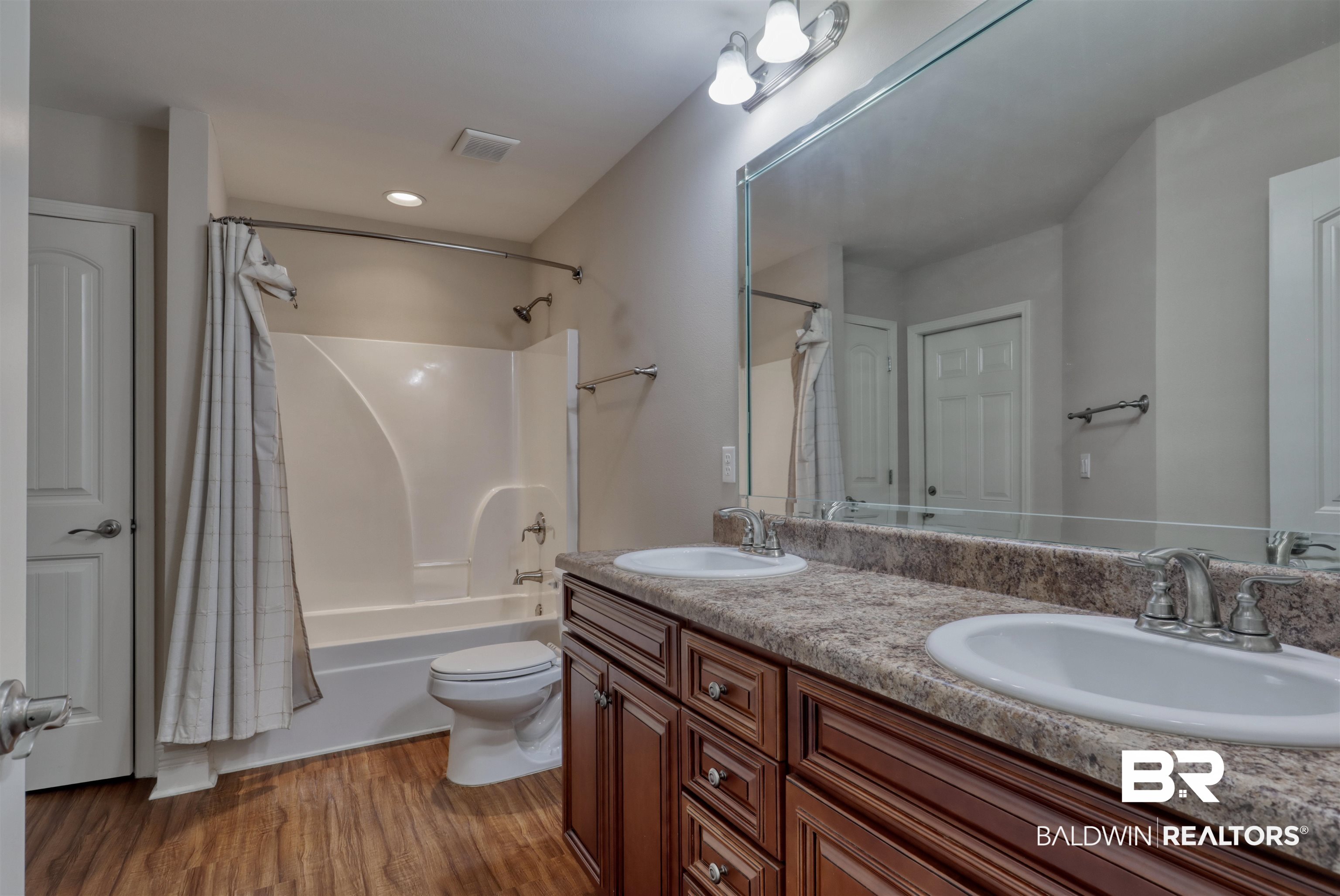 14794 Troon Drive Foley, AL 36535 - Photo 21 of 33 Full bathroom featuring double vanity, visible vents, a sink, and wood finished floors