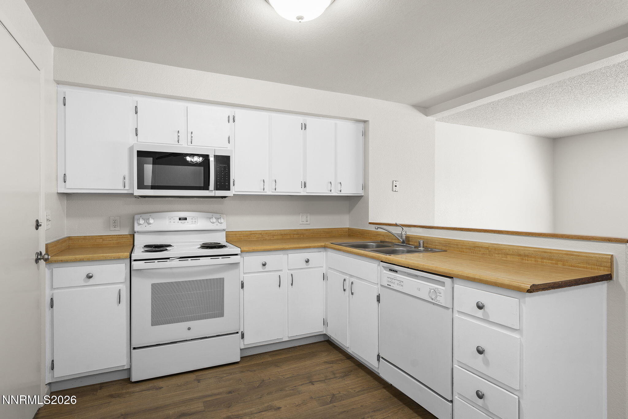 401 Allouette Way, Unit 2 Carson City, NV 89701 - Photo 12 of 29 a kitchen with granite countertop white cabinets and white appliances