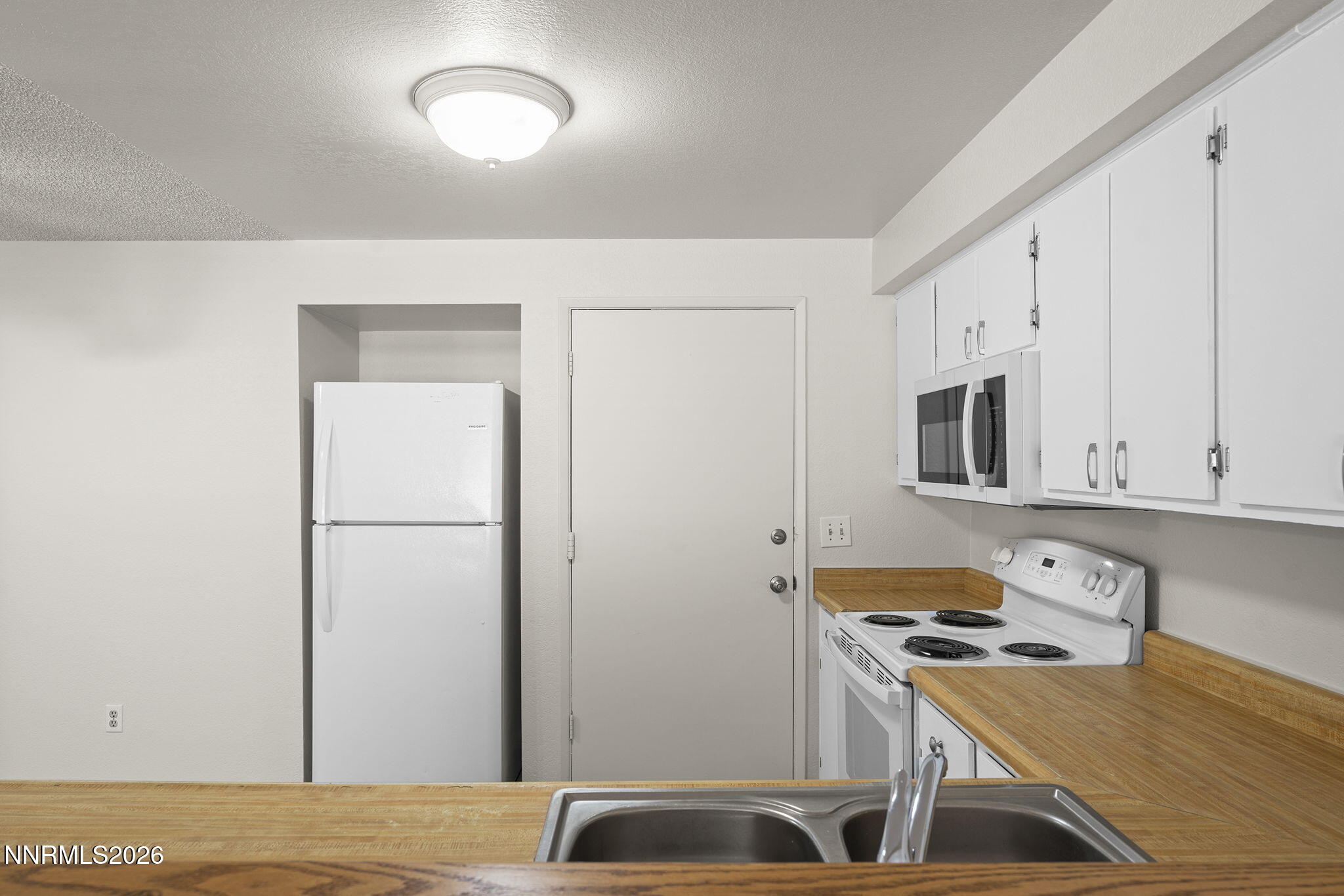 401 Allouette Way, Unit 2 Carson City, NV 89701 - Photo 14 of 29 a kitchen with stainless steel appliances granite countertop a refrigerator a stove and white cabinets with wooden floor