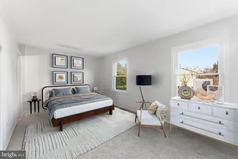 a view of a hallway with wooden floor and a bathroom