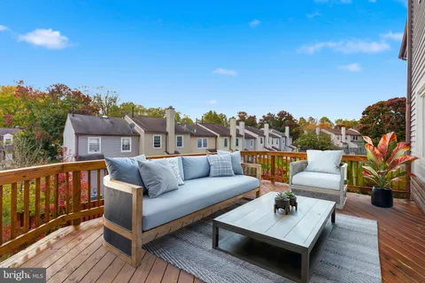 a roof deck with couches and wooden floor