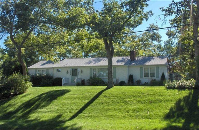 a view of a house next to a yard with plants and trees