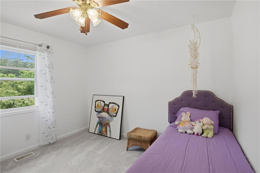 338 Arbour Way Suwanee, GA 30024 - Photo 14 of 32 a bedroom with a bed and a chandelier