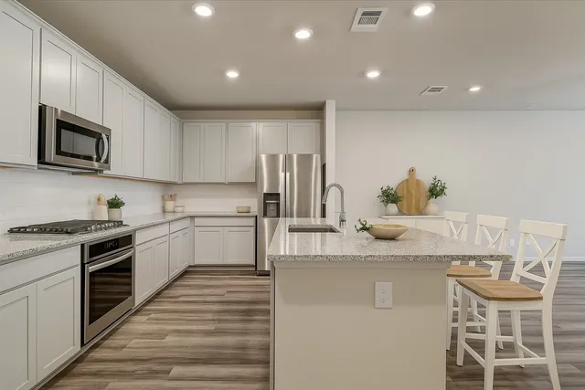a kitchen with stainless steel appliances granite countertop a sink and cabinets