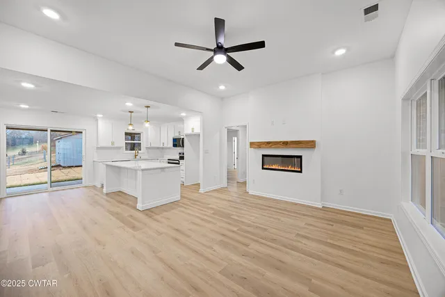 a view of kitchen with granite countertop cabinets and window