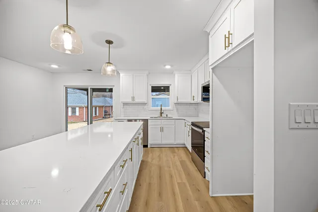 a kitchen with a sink a counter top space stainless steel appliances and cabinets
