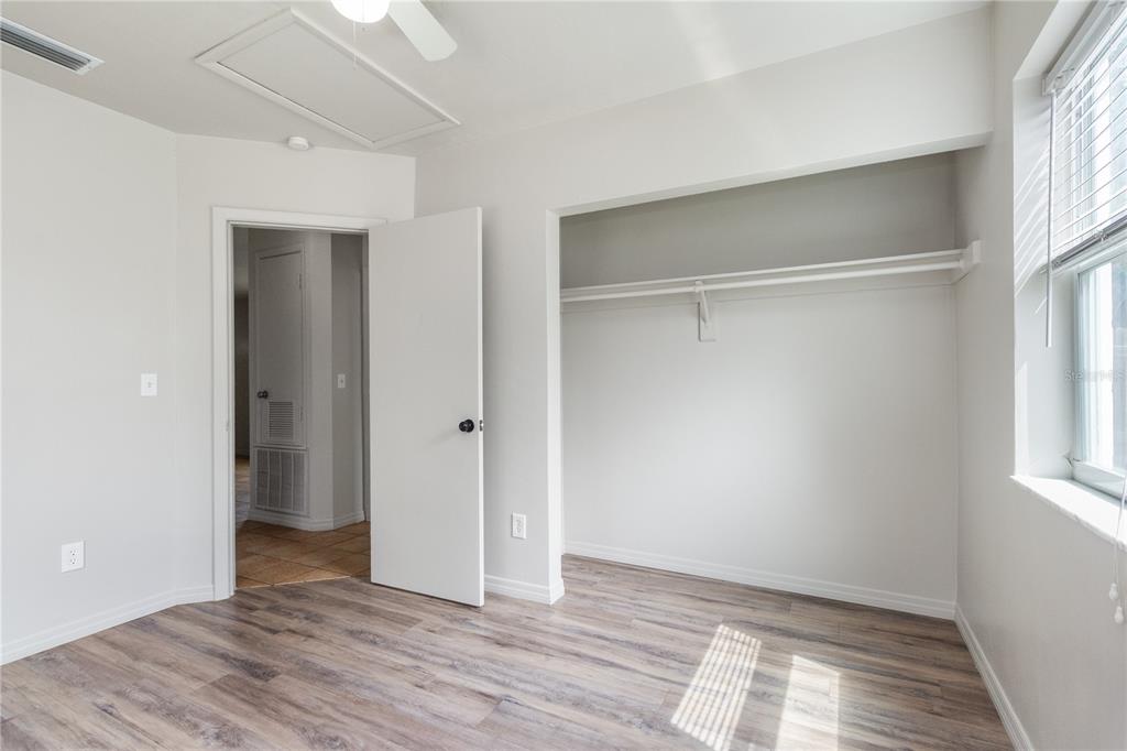 7208 Fair Oaks Street Spring Hill, FL 34606 - Photo 14 of 25 a view of an empty room with wooden floor and a window