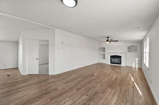 a view of empty room with wooden floor and fireplace