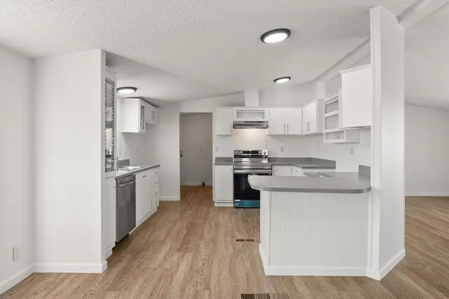 a kitchen with a sink a refrigerator and cabinets