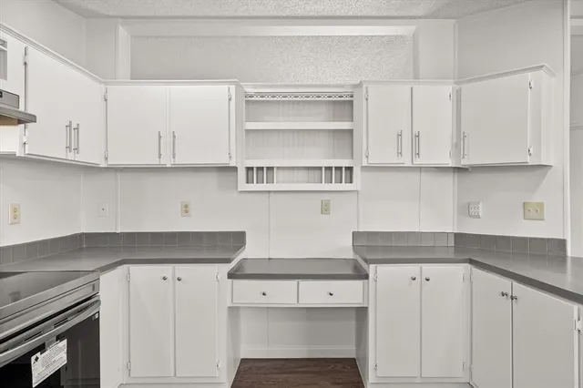 a kitchen with white cabinets and a stove