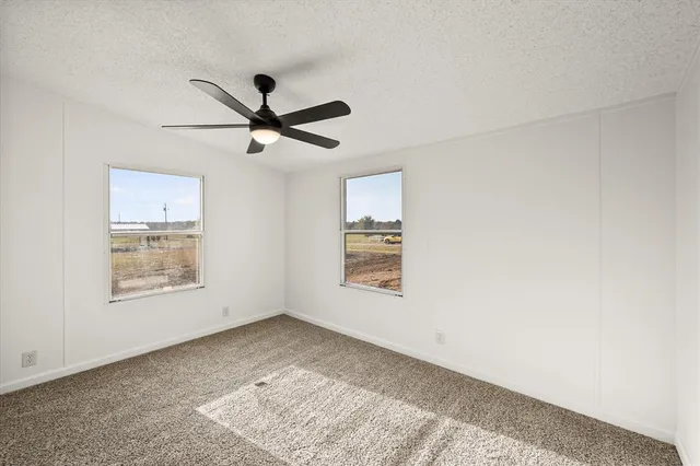 a view of empty room with fan and window