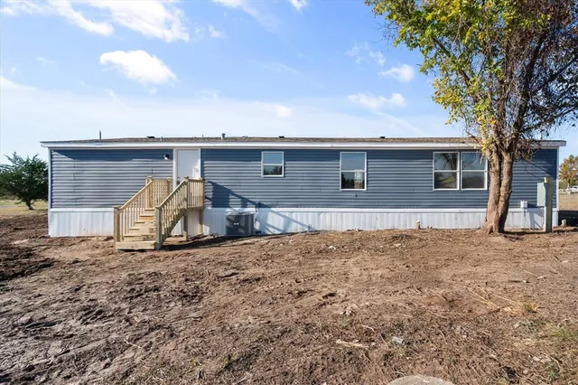 a view of a house with a tree and a yard