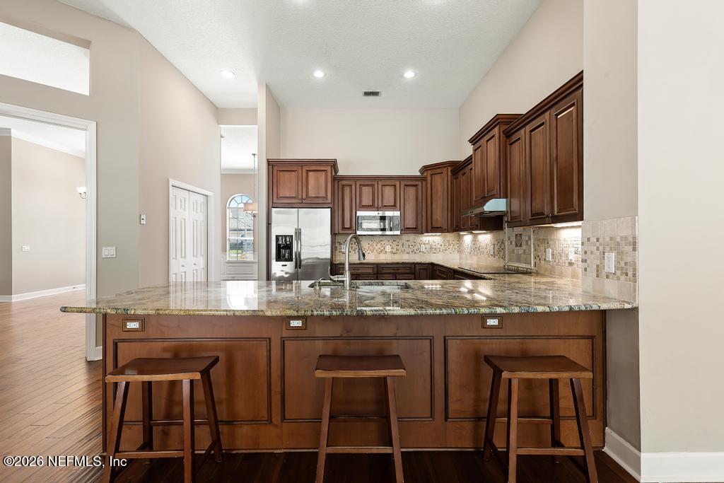 337 South Mill View Way Ponte Vedra Beach, FL 32082 - Photo 20 of 55 a kitchen with kitchen island granite countertop a table chairs sink and cabinets