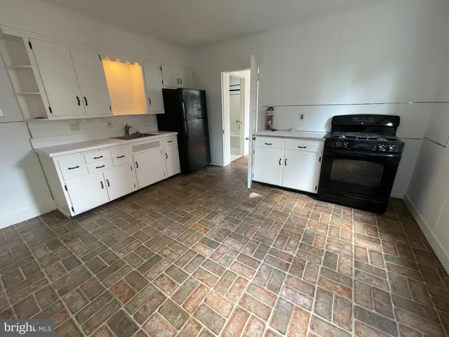 a kitchen with a stove a refrigerator and cabinets