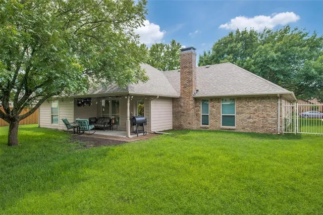 a front view of a house with a garden and trees