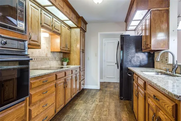 a kitchen with stainless steel appliances granite countertop a sink and a refrigerator