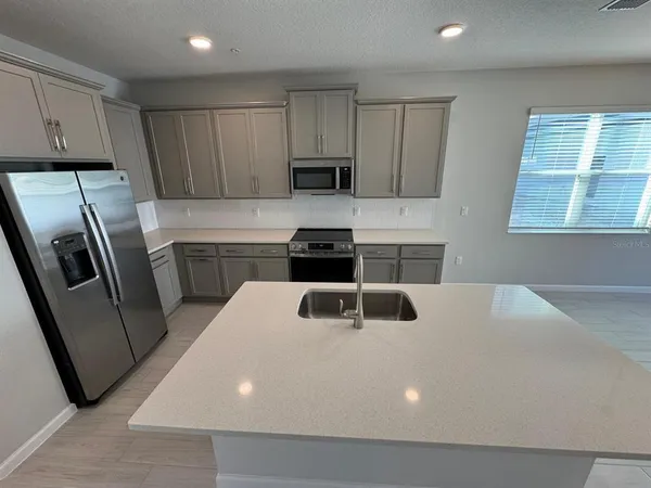 a kitchen with sink a refrigerator and cabinets