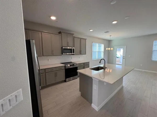 a kitchen with kitchen island a sink stainless steel appliances and cabinets