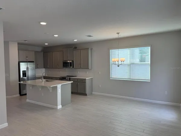 a kitchen with stainless steel appliances granite countertop a stove top oven a sink dishwasher and a refrigerator