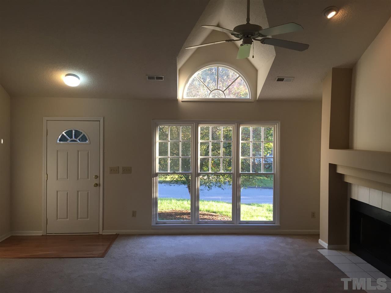 3541 Dechart Lane Raleigh, NC 27616 - Photo 3 of 9 an empty room with a fireplace and windows