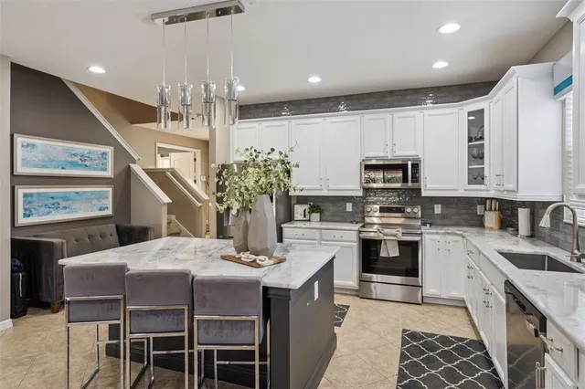 a kitchen with stainless steel appliances kitchen island granite countertop a kitchen island hardwood floor sink and stove