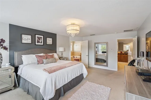 a bedroom with a large bed and a chandelier